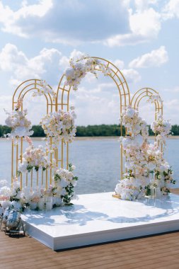 Törensel altın düğün kemeri suyun yakınındaki iskelede.