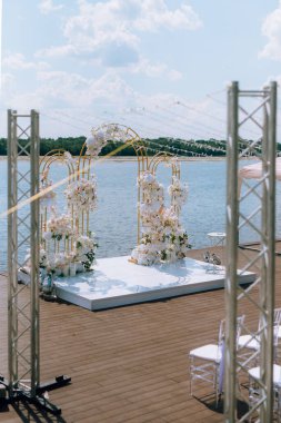 Törensel altın düğün kemeri suyun yakınındaki iskelede.