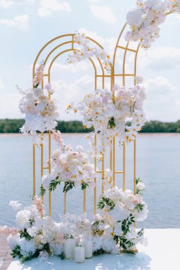 Törensel altın düğün kemeri suyun yakınındaki iskelede.