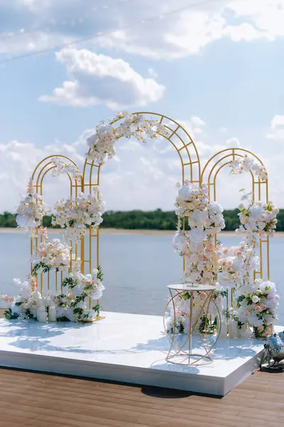 Törensel altın düğün kemeri suyun yakınındaki iskelede.