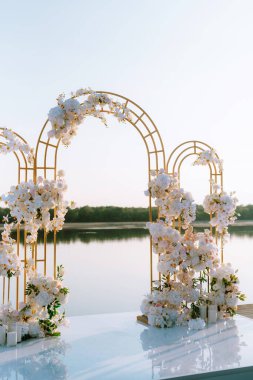 Törensel altın düğün kemeri suyun yakınındaki iskelede.