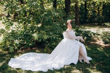 Bahar bahçesinde gelinlik giymiş genç bir kız.