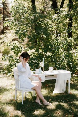 Bahar bahçesinde gelinlik giymiş genç bir kız.