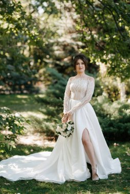 Bahar bahçesinde gelinlik giymiş genç bir kız.