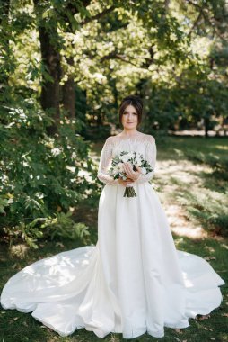 Bahar bahçesinde gelinlik giymiş genç bir kız.