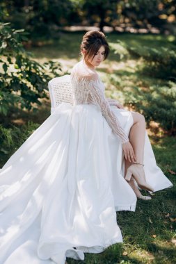 Bahar bahçesinde gelinlik giymiş genç bir kız.