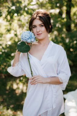 Bahar bahçesinde gelinlik giymiş genç bir kız.