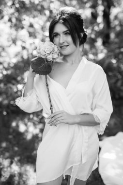 Bahar bahçesinde gelinlik giymiş genç bir kız.