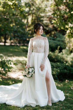 Bahar bahçesinde gelinlik giymiş genç bir kız.