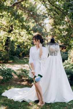 Bahar bahçesinde gelinlik giymiş genç bir kız.