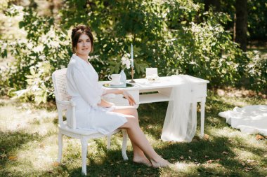 Bahar bahçesinde gelinlik giymiş genç bir kız.