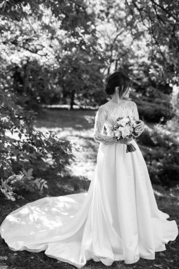 Bahar bahçesinde gelinlik giymiş genç bir kız.