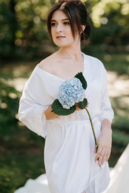 Bahar bahçesinde gelinlik giymiş genç bir kız.