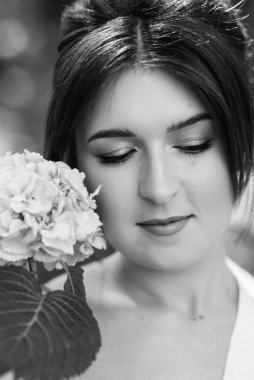 Bahar bahçesinde gelinlik giymiş genç bir kız.