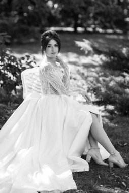 Bahar bahçesinde gelinlik giymiş genç bir kız.