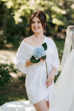 Bahar bahçesinde gelinlik giymiş genç bir kız.