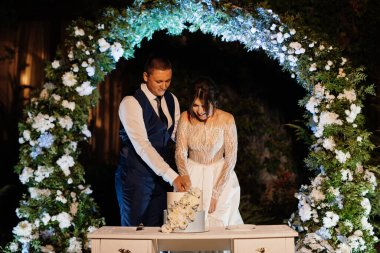 newlyweds happily cut, laugh and taste the wedding cake