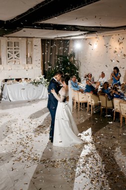 Gelin ve damadın ilk düğün dansı gün batımında restoranın içinde.