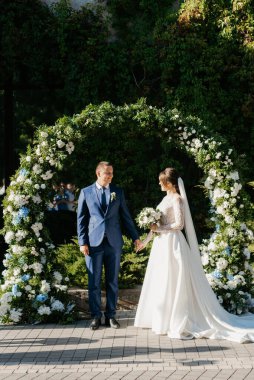 Yeni evlilerin düğün töreni. Restoranın yakınındaki meydanda.
