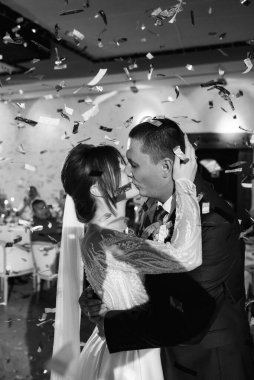 Gelin ve damadın ilk düğün dansı gün batımında restoranın içinde.