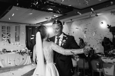 Gelin ve damadın ilk düğün dansı gün batımında restoranın içinde.