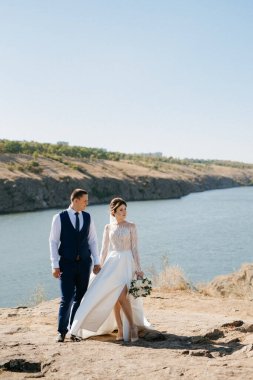 bride blonde girl and groom near the river at sunset light