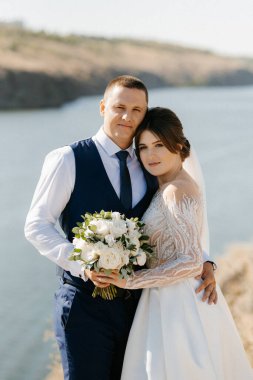 bride blonde girl and groom near the river at sunset light