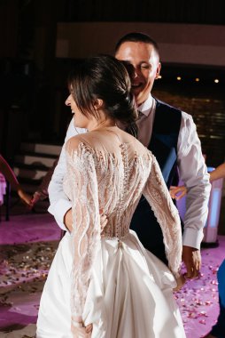 Gelin ve damadın ilk düğün dansı gün batımında restoranın içinde.