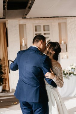 Gelin ve damadın ilk düğün dansı gün batımında restoranın içinde.