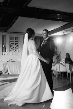 Gelin ve damadın ilk düğün dansı gün batımında restoranın içinde.