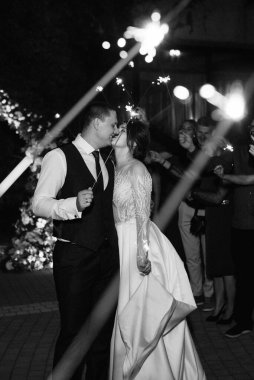 newlyweds at a wedding in the corridor of sparklers