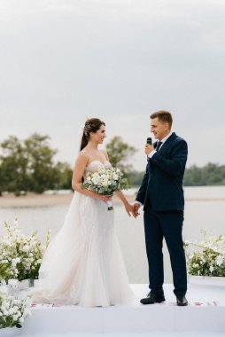 wedding ceremony of the newlyweds on the pier near the restaurant