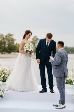 wedding ceremony of the newlyweds on the pier near the restaurant