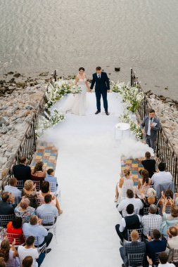 wedding ceremony of the newlyweds on the pier near the restaurant