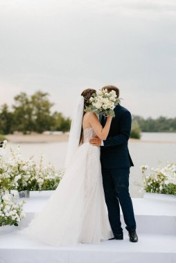 wedding ceremony of the newlyweds on the pier near the restaurant