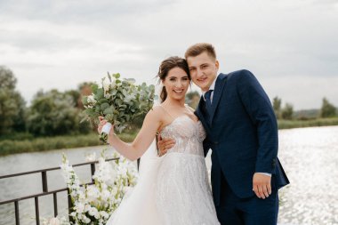 wedding ceremony of the newlyweds on the pier near the restaurant