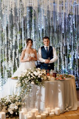 Yeni evlilerin portresi düğün şöleninde başkanlık makamında.