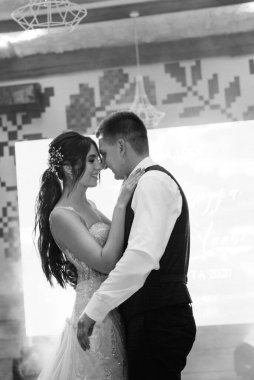 the first dance of the bride and groom inside a restaurant with heavy smoke