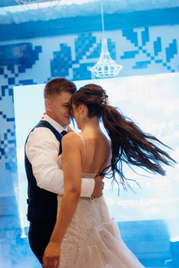 the first dance of the bride and groom inside a restaurant with heavy smoke