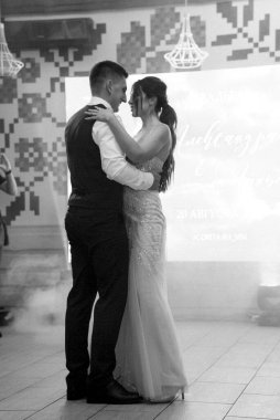 the first dance of the bride and groom inside a restaurant with heavy smoke