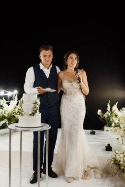 newlyweds happily cut, laugh and taste the wedding cake