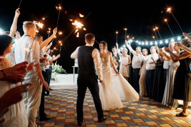newlyweds at a wedding in the corridor of sparklers