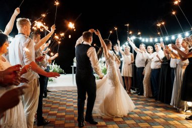 newlyweds at a wedding in the corridor of sparklers