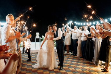 newlyweds at a wedding in the corridor of sparklers