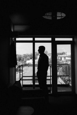 Düğün günü otelde kravatlı, mavi takım elbiseli bir damat portresi.