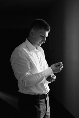 Düğün günü otelde kravatlı, mavi takım elbiseli bir damat portresi.