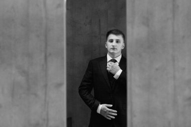 Düğün günü otelde kravatlı, mavi takım elbiseli bir damat portresi.