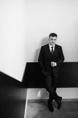 Düğün günü otelde kravatlı, mavi takım elbiseli bir damat portresi.