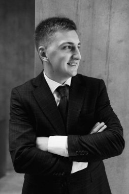 Düğün günü otelde kravatlı, mavi takım elbiseli bir damat portresi.