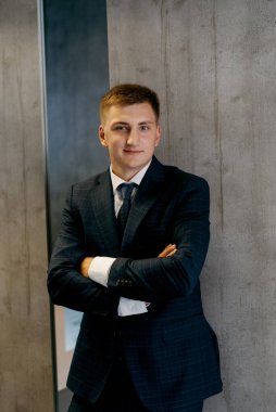 Düğün günü otelde kravatlı, mavi takım elbiseli bir damat portresi.